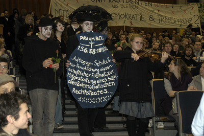 Symbolisch wird die Präambel der Grundordnung der Universität zu Grabe getragen.